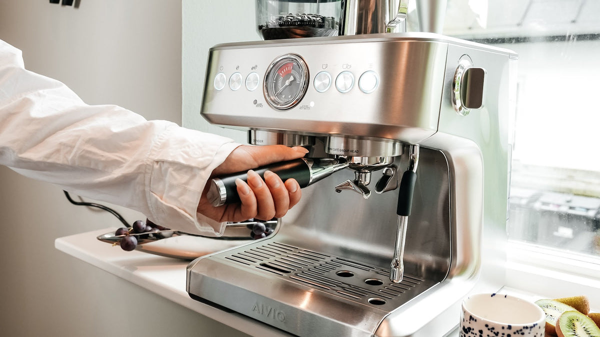 Eine Hand setzt im Morgenlicht den Siebträger in eine Aspire Brew