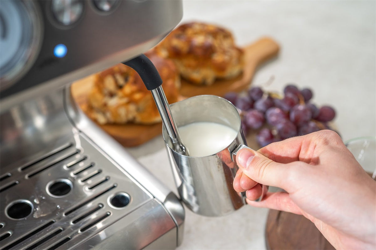 Milch wird mit der Dampflanze einer Aspire Core geschäumt