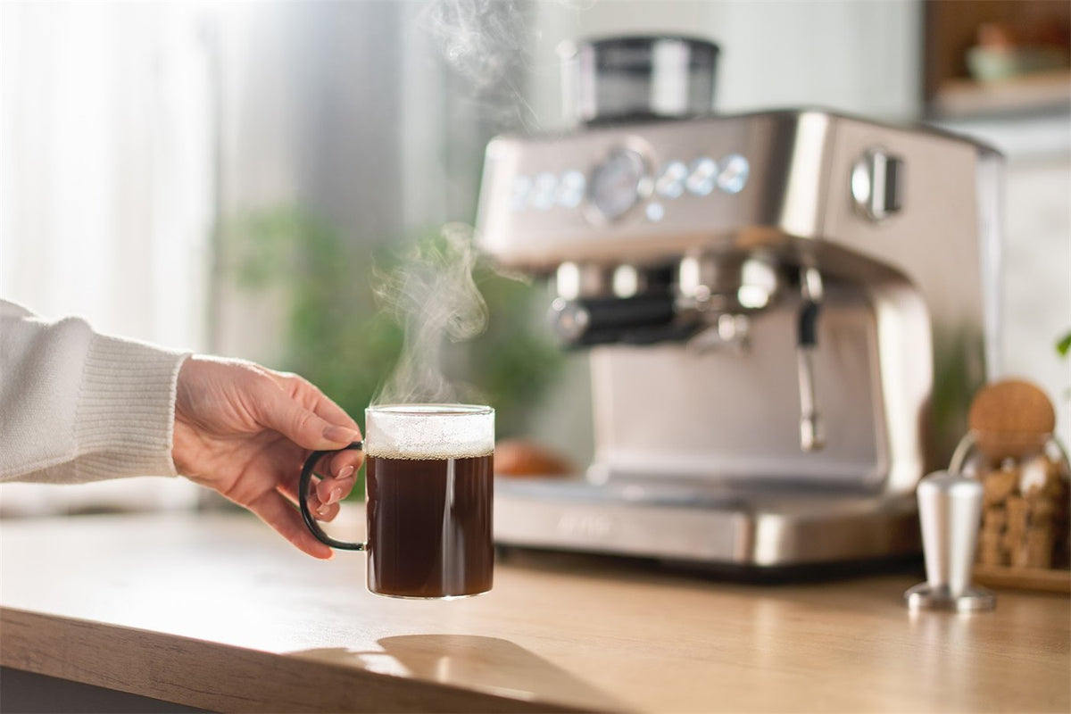 Eine Tasse Kaffee neben der Aspire Core auf einer hellen Arbeitsplatte