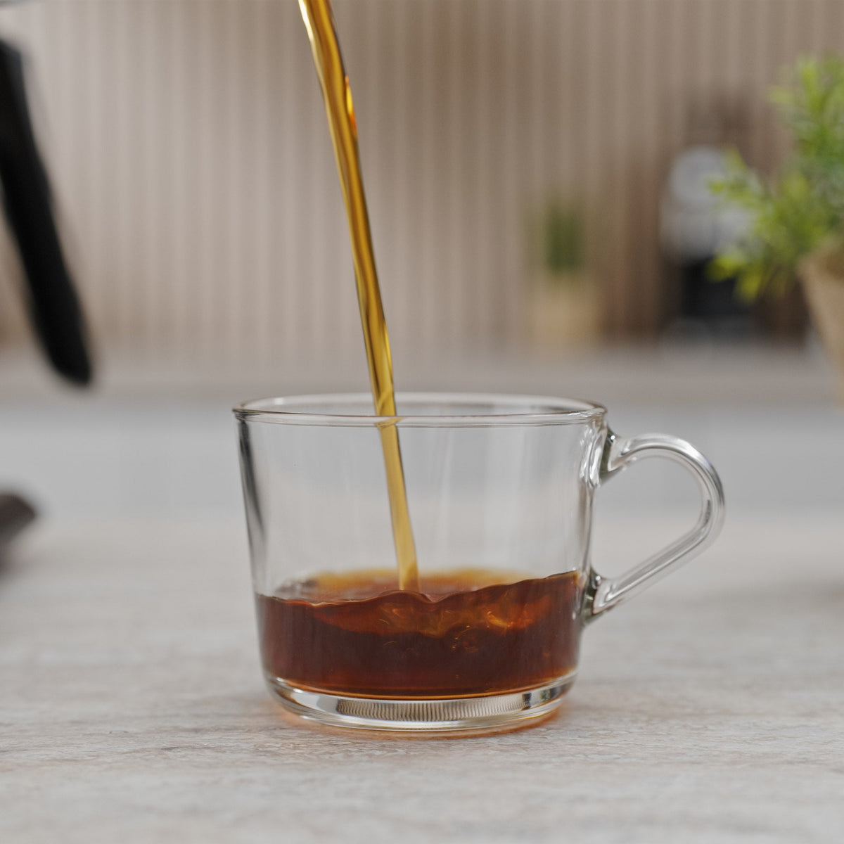 Precision Pour Pro gießt Kaffee in eine Glastasse